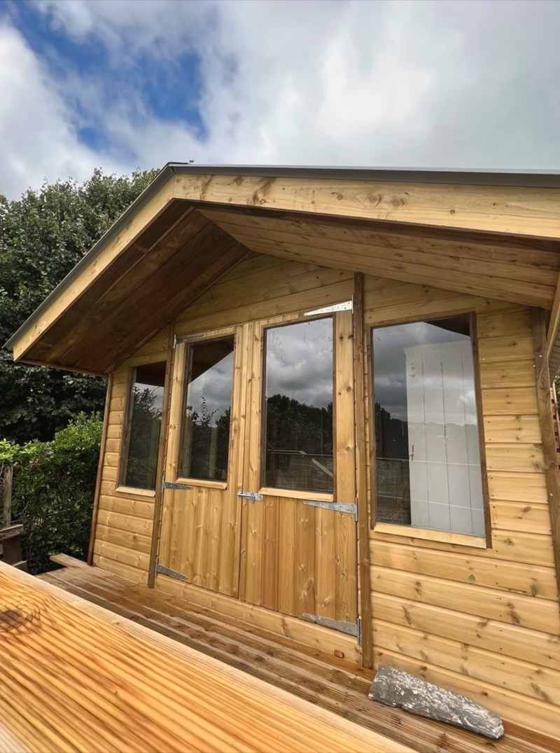 A bespoke timber summerhouse with glazed doors and a deck