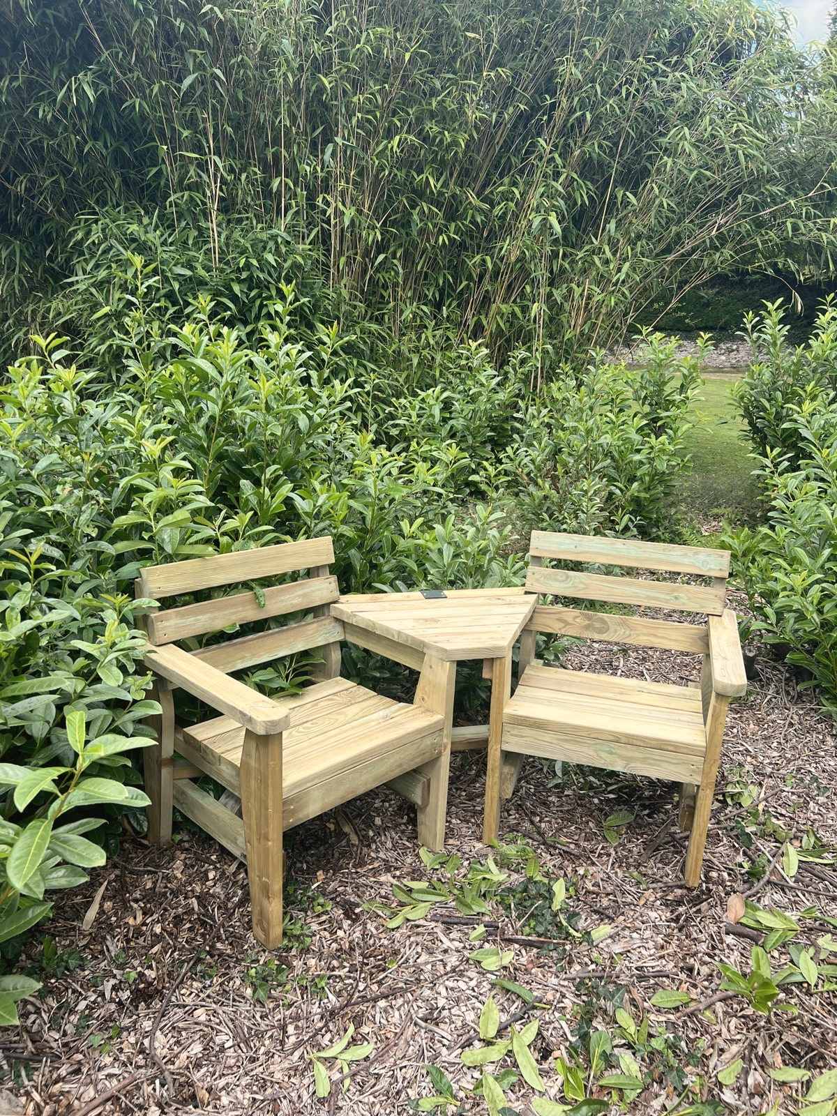 A love chair, two angled timber seats with a table between them