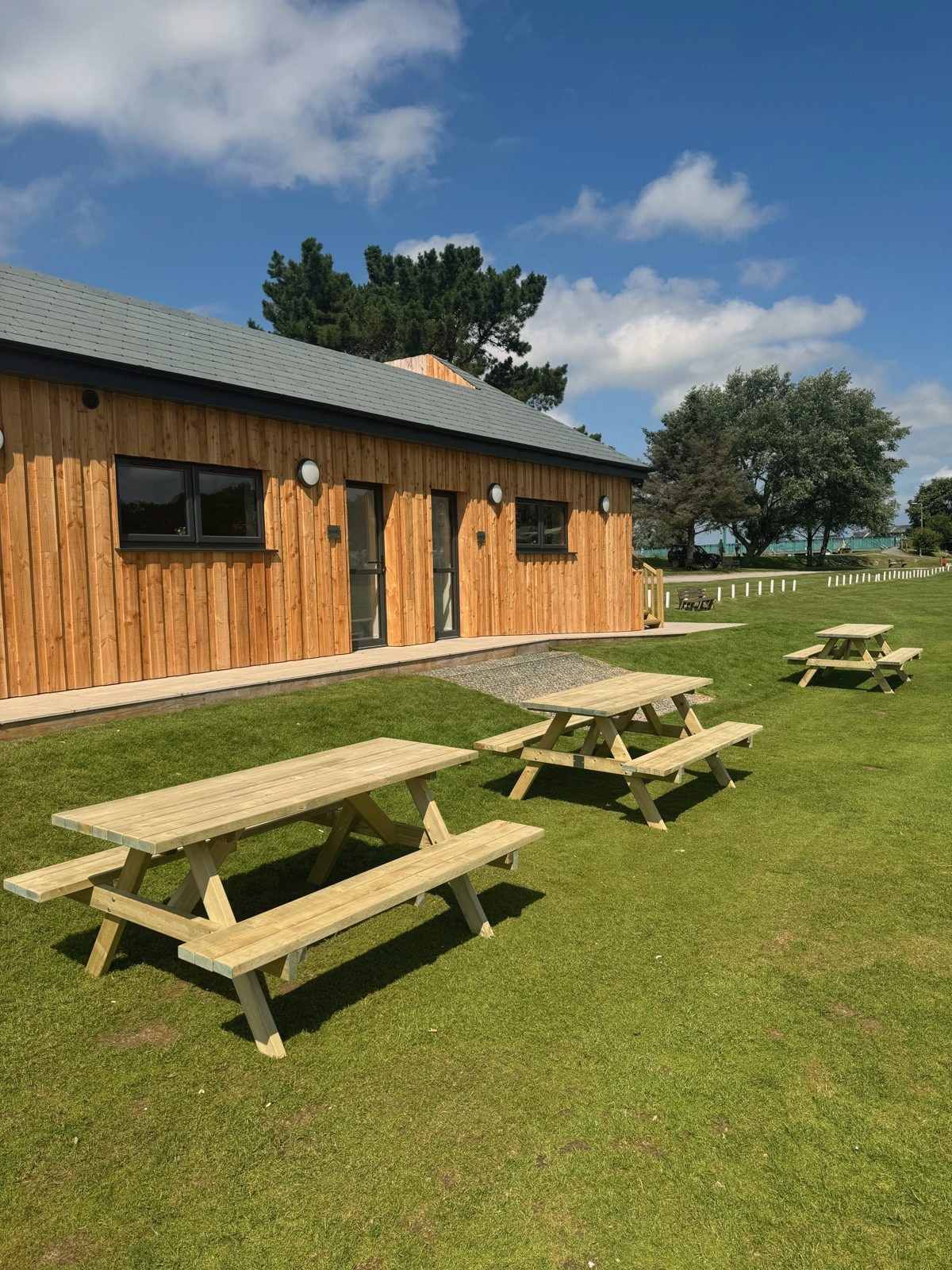 A heavy-duty timber picnic bench on a lawn