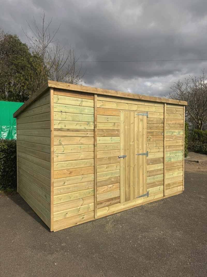A pent-roof shed with a double door on a drive